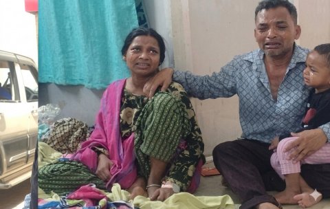 चलती ट्रेन से बच्चा फेंकने के आरोप में हिरासत में ली गई महिला और उसका रोता हुआ परिवार।